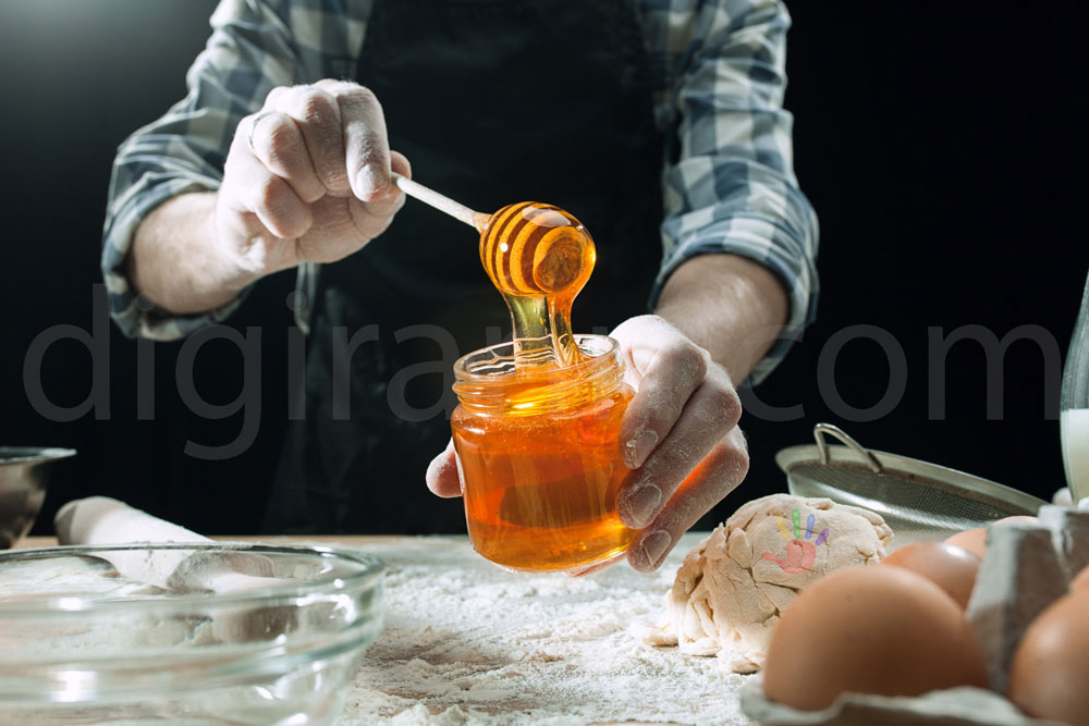 نمایی از بررسی شرایط و کیفیت عسل توسط سرآشپز برای پخت کیک و شیرینی با پودر آرد تخم مرغ خمیر
