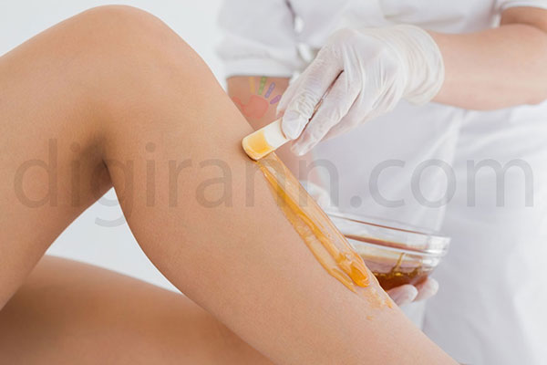 نمایی از عسل درمانی با گذاشتن ماسک عسل روی پوست بدن زن جوان توسط پزشک برای برداشت خال با عسل