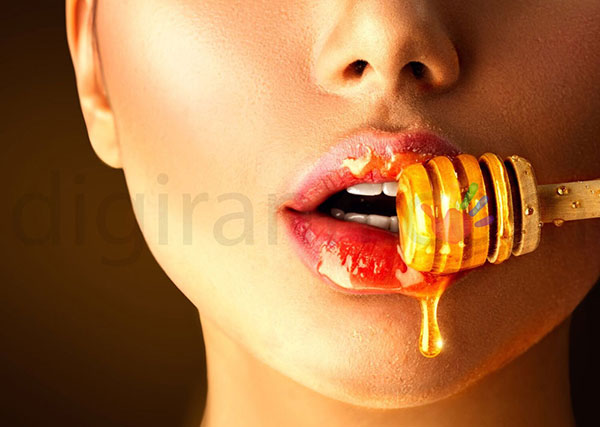 استفاده عسل برای دندان درد، خوردن آن با قاشق چوبی عسلخوری یک زن جوان