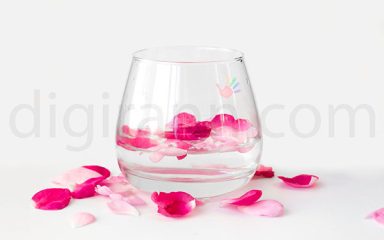 تصویری از تنگ شیشه ای محتوی گلبرگ هایی از گل محمدی سفید صورتی و قرمز برای ذکر خواص گلاب برای بدن