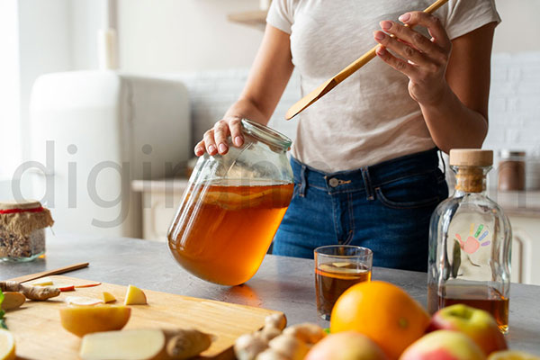 نمایی از بهترین محل نگهداری عسل در ظروف شیشه ای در خانه همراه میوه هایی مثل سیب پرتقال موز خارج از یخچال در کابینت یا کمد