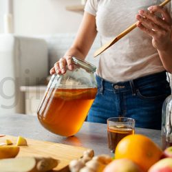 نمایی از بهترین محل نگهداری عسل در ظروف شیشه ای در خانه همراه میوه هایی مثل سیب پرتقال موز خارج از یخچال در کابینت یا کمد